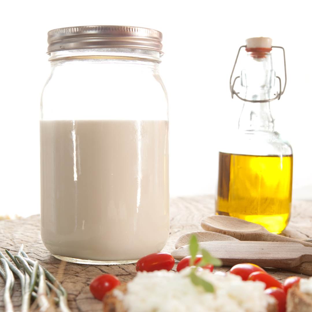 a bottle of goat milk and olive oil on the table