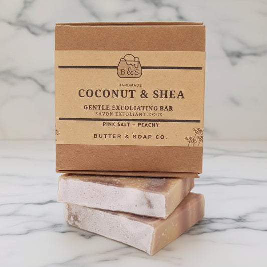 Coconut and Shea Gentle Exfoliating Bar with packaging on marble counter background