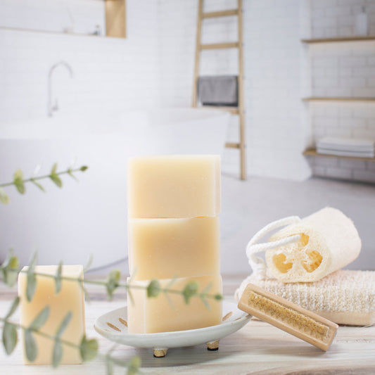 Bath products including candles, loofah, and soap on a bathroom counter.